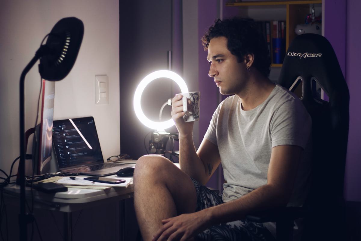 A creator recording himself at a desk with a ring light and microphone