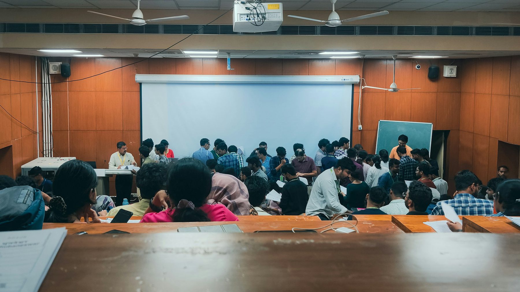A full Indian lecture hall with the professor teaching at the front