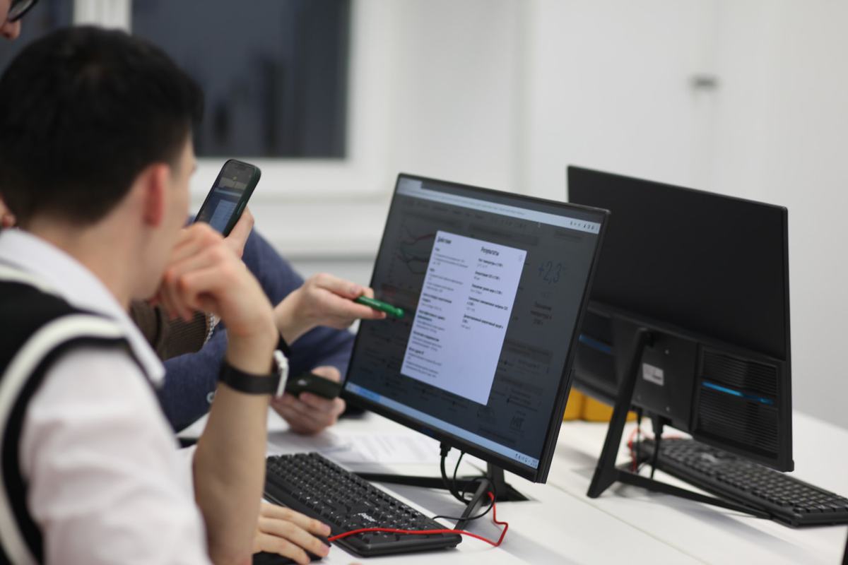 A team reviewing course builds together on laptops